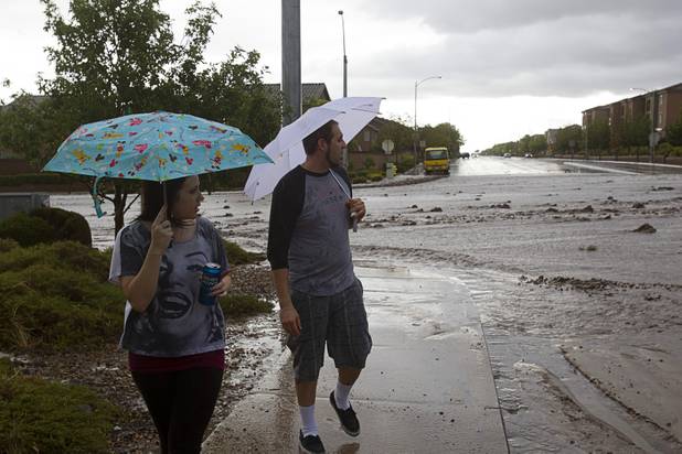 A couple looks over flooding on Grand Teton Drive near Grand Canyon Drive Sunday, Aug. 25, 2013.