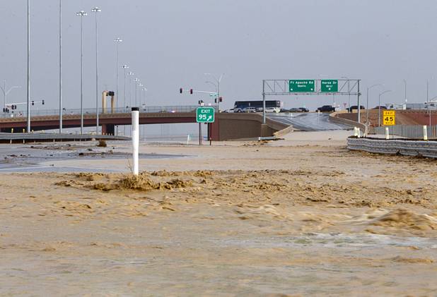 Storm runoff flows over the roadway on U.S.95 southbound by the Horse Drive/Fort Apache Road exit Sunday, Aug. 25, 2013.