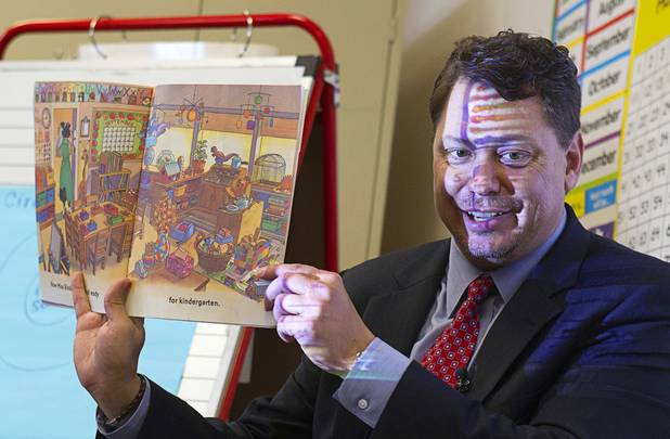An overhead projector puts a pattern on the face of Clark County School District Superintendent Pat Skorkowsky as he reads to kindergarten students during the first day of school at Cambeiro Elementary School Monday, Aug. 26, 2013. The school is a "Zoom" school, one of 14 CCSD schools that will receive additional state money and resources to help students who don't speak English.