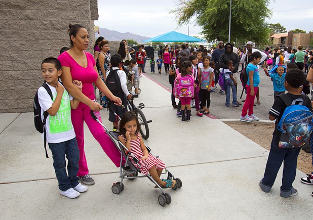 Third grader Christian Herrera waits with his mother and sister Karime, a kindergarten student, as the wait for the start of school at Cambeiro Elementary School Monday, Aug. 26, 2013. The school is a "Zoom" school, one of 14 CCSD schools that will receive additional state money and resources to help students who don't speak English.