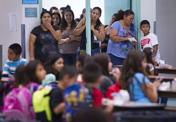 Parents watch from a doorway as students eat breakfast during the first day of school at Cambeiro Elementary School Monday, Aug. 26, 2013. The school is a "Zoom" school, one of 14 CCSD schools that will receive additional state money and resources to help students who don't speak English.