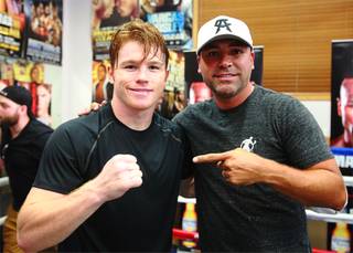Boxer Canelo Alvarez, left, of Mexico poses with Oscar De La Hoya in Big Bear, Calif. Tuesday, August 27, 2013. Alvarez will face undefeated boxer Floyd Mayweather Jr. in a WBC/WBA 154-pound title fight at the MGM Grand Garden Arena in Las Vegas on September 14. Hogan Photos/Golden Boy Promotions
