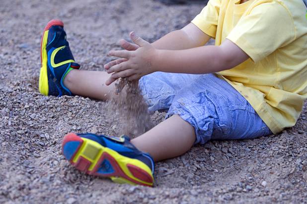 A student plays with gravel during a grand opening ceremony for the 9th Bridge School in downtown Las Vegas Tuesday, Aug. 27, 2013. The private school/early childhood learning center, part of the Downtown Project, opened August 26 with infants through kindergarten students and will gradually add grades.