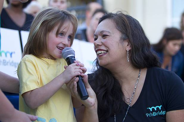 Bella Castellarin, 5, helps Lori Ann Malina, curriculum director, with a grand opening ceremony for the 9th Bridge School in downtown Las Vegas Tuesday, Aug. 27, 2013. The private school/early childhood learning center, part of the Downtown Project, opened August 26 with infants through kindergarten students and will gradually add grades.