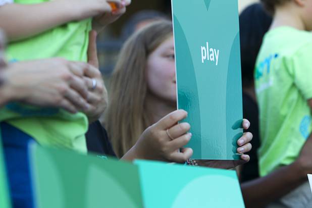 Students and staff hold up cards with nine principles of the school during a grand opening ceremony for the 9th Bridge School in downtown Las Vegas Tuesday, Aug. 27, 2013. The private school/early childhood learning center, part of the Downtown Project, opened August 26 with infants through kindergarten students and will gradually add grades.