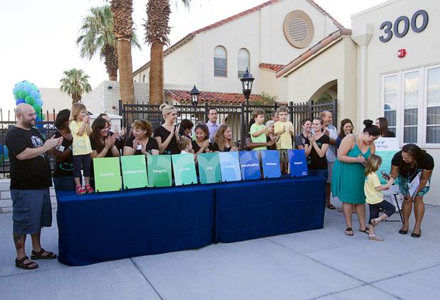 Students, parents and staff display cards with nine principles of the school during a grand opening ceremony for the 9th Bridge School in downtown Las Vegas Tuesday, Aug. 27, 2013. The private school/early childhood learning center, part of the Downtown Project, opened August 26 with infants through kindergarten students and will gradually add grades.