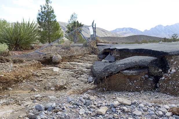 Damage is shown to a driveway and fencing on Scottie Street in Lower Kyle Canyon Road Tuesday, Aug. 27, 2013. The area was hit hard by storm runoff during Sunday's storm. Kyle Canyon Road reopened to the public Tuesday.