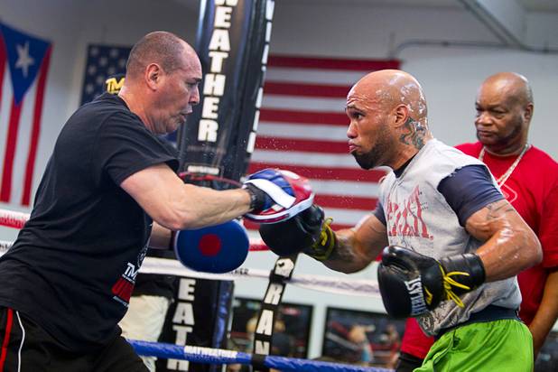 IBF 154-pound champion Ishe Smith, right, works on his timing with assistant trainer Rafael Ramos at the Mayweather Boxing Club Wednesday, August 28, 2013. Head trainer Eddie Mustafa Muhammad watches at far right. Smith will defend his title against Carlos Molina of Mexico at the MGM Grand Garden Arena on September 14.
