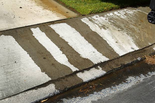 Water from a lawn sprinkler flows into the gutter at a home near Rancho Dr. and Oakey Blvd. Thursday, August 29, 2013.