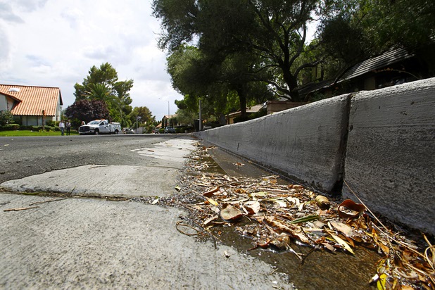 Water flows down the street from a home near Rancho Dr. and Oakey Blvd. Thursday, August 29, 2013. The lawn sprinklers were running at a prohibited time (between 11 a.m. and 7 p.m.) and overwatering so that water flowed into the gutter.