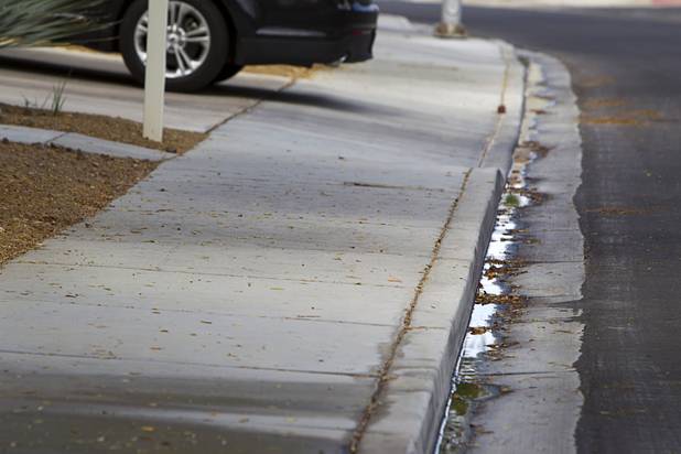 Water flows down the street from a home near Rancho Dr. and Oakey Blvd. Thursday, August 29, 2013. The lawn sprinklers were running at a prohibited time (between 11 a.m. and 7 p.m.) and overwatering so that water flowed into the gutter.