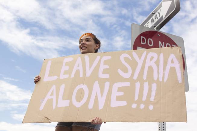 Morgan Pavlich hold up a "Leave Syria Alone" sign during a protest against U.S. intervention in Syria held on Tropicana and the I-15, Saturday, Aug. 31, 2013.