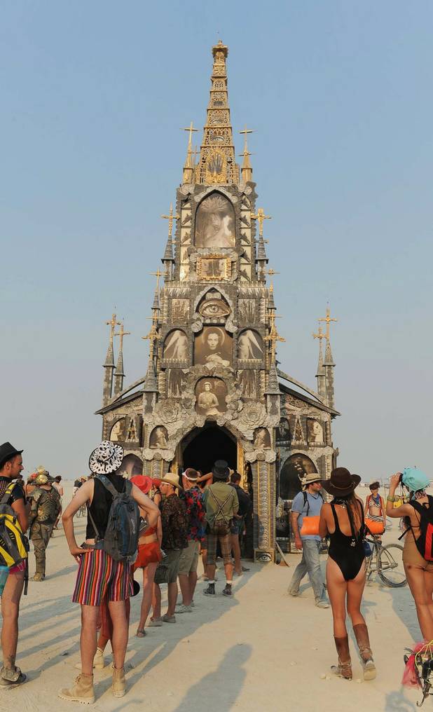 In this Wednesday, Aug. 28, 2013 photo, people gather at the "Photo Chapel" at Burning Man in Gerlach, Nev. Once a year, tens of thousands of participants gather for Burning Man in Nevada's Black Rock Desert to create Black Rock City, dedicated to community, art, self-expression and self-reliance.