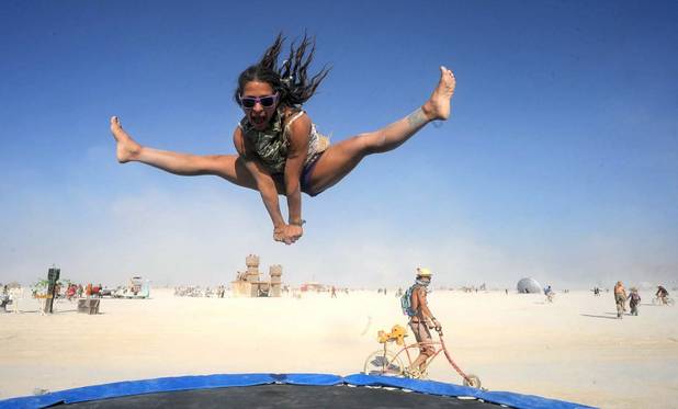 In this Aug. 29, 2013, photo, Selam Borges plays on a trampoline at Burning Man in Gerlach, Nev. Once a year, tens of thousands of participants gather for Burning Man in Nevada's Black Rock Desert to create Black Rock City, dedicated to community, art, self-expression and self-reliance.