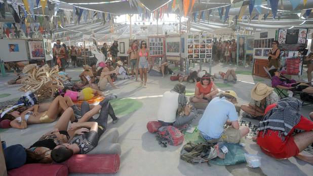 In this Thursday, Aug. 29 photo, people relax inside Center Camp at Burning Man in Gerlach, Nev. Once a year, tens of thousands of participants gather for Burning Man in Nevada's Black Rock Desert to create Black Rock City, dedicated to community, art, self-expression and self-reliance. 