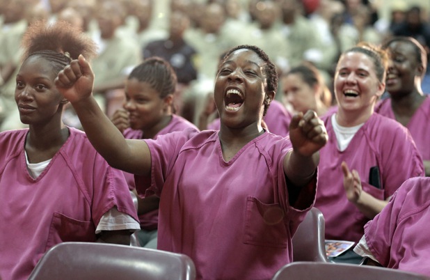 In this Aug. 27, 2013, photo, inmate Kristy Montgomery cheers from her seat while watching rappers perform a hip hop adaptation of William Shakespeare's Othello, titled "Othello: The Remix" at the Cook County Jail in Chicago. Montgomery, 29, said she came away from the play believing it had an important message: "Be careful of who you affiliate yourself with because they might not actually be your friends. They might be somebody who wants to bring you down." Its a lesson, she says, shell try to heed "because I befriend the wrong people all the time." 
