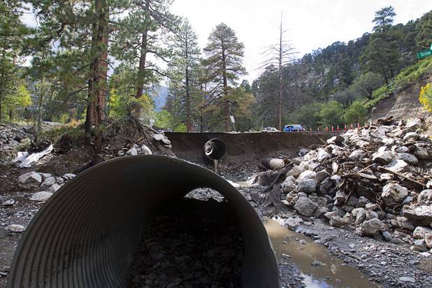 Damage to Rainbow Canyon Boulevard is shown at Kyle Canyon Road after heavy storm runoff tore through the Rainbow Canyon subdivision on Mount Charleston Sunday, Sept. 1, 2013.