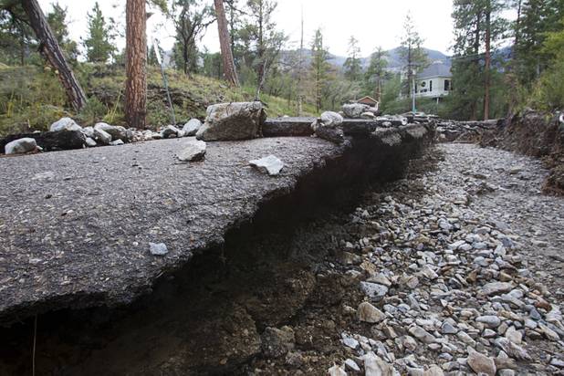 Damage to Rainbow Canyon Boulevard is shown after heavy storm runoff tore through the Rainbow Canyon subdivision on Mount Charleston Sunday, Sept. 1, 2013.