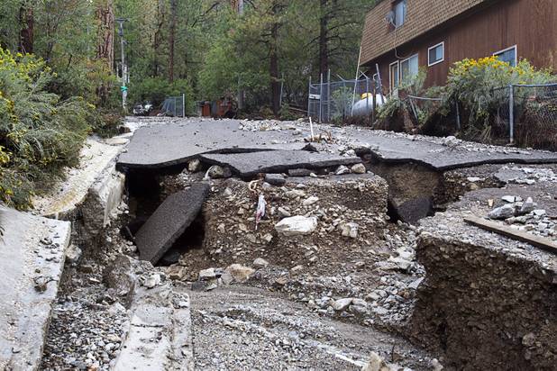 Damage to Rainbow Canyon Boulevard is shown after heavy storm runoff tore through the Rainbow Canyon subdivision on Mount Charleston Sunday, Sept. 1, 2013.