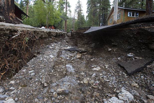 Damage to Rainbow Canyon Boulevard is shown after heavy storm runoff tore through the Rainbow Canyon subdivision on Mount Charleston Sunday, Sept. 1, 2013.