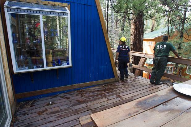 Nevada Division of Forestry firefighters Martha Law, left, and Jorge Gonzalez check homes after heavy storm runoff tore through the Rainbow Canyon subdivision on Mount Charleston Sunday, Sept. 1, 2013.