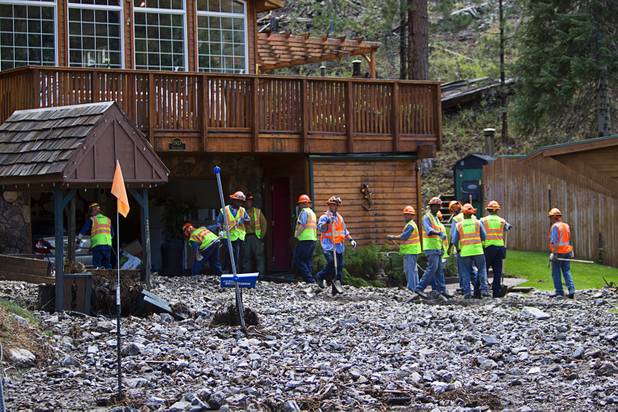 A crew clears out a garage after heavy storm runoff tore through the Rainbow Canyon subdivision on Mount Charleston Sunday, Sept. 1, 2013.