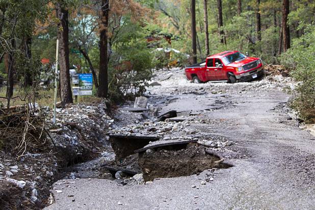 Damage to Rainbow Canyon Boulevard is shown after heavy storm runoff tore through the Rainbow Canyon subdivision on Mount Charleston Sunday, Sept. 1, 2013.