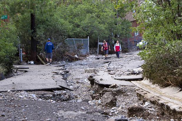 Red Cross volunteers hike up Rainbow Canyon Boulevard after heavy storm runoff tore through the Rainbow Canyon subdivision on Mount Charleston Sunday, Sept. 1, 2013.