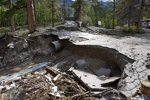 Damage to Rainbow Canyon Boulevard is shown at Kyle Canyon Road after heavy storm runoff tore through the Rainbow Canyon subdivision on Mount Charleston Sunday, Sept. 1, 2013.