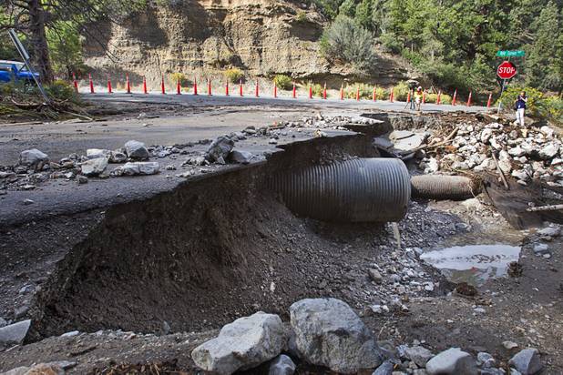 Damage to Rainbow Canyon Boulevard is shown at Kyle Canyon Road after heavy storm runoff tore through the Rainbow Canyon subdivision on Mount Charleston Sunday, Sept. 1, 2013.