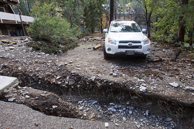 A SUV is cut off from Rainbow Canyon Boulevard after heavy storm runoff tore through the Rainbow Canyon subdivision on Mount Charleston Sunday, Sept. 1, 2013.