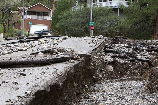Rainbow Canyon Boulevard, left, is shown by Bristlecone Pine Drive after heavy storm runoff tore through the Rainbow Canyon subdivision on Mount Charleston Sunday, Sept. 1, 2013.