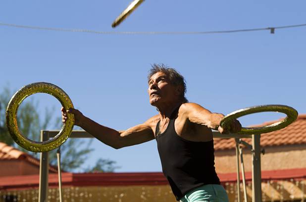 Nino Frediani, 73, catches a ring thrown by Pam Sullivan, general manager of "Unstoppable," with his head in his backyard Tuesday, Sept. 3, 2013. Frediani is the producer of "Unstoppable," a variety show featuring performers who are 60 years old and older.