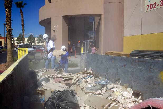 Steven Ellis, of M&M's World Las Vegas, and Jen Gudgel, Ethel M director of gourmet chocolate, discard construction debris during volunteer work on the Habitat for Humanity ReStore at the old Tower Records store, 4580 W. Sahara Ave., Wednesday, Sept. 4, 2013. The project is part of M&M's campaign to encourage Americans to help MProve America through a national partnership with Habitat for Humanity. 