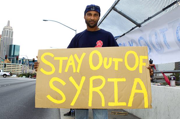 Paul Gones poses with his sign during a protest at the Tropicana Avenue overpass above I-15 Saturday, Sept. 7, 2013. About 50 people attended the protest.
