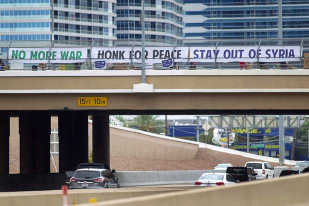 People express their opposition to proposed U.S. military action in Syria during a protest at the Tropicana Avenue overpass above I-15 Saturday, Sept. 7, 2013. About 50 people attended the protest.
