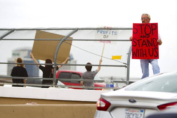 Robert Walker holds a sign at the I-15 offramp to Tropicana eastbound during a protest to proposed U.S. military action in Syria Saturday, Sept. 7, 2013. About 50 people attended the protest.