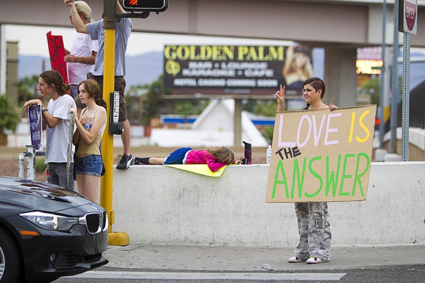 MacKenzie Holt, right, holds a sign at the I-15 offramp to Tropicana eastbound during a protest to proposed U.S. military action in Syria Saturday, Sept. 7, 2013. About 50 people attended the protest.