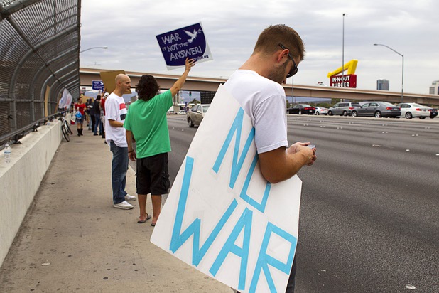 People express their opposition to proposed U.S. military action in Syria during a protest at the Tropicana Avenue overpass above I-15 Saturday, Sept. 7, 2013. About 50 people attended the protest.