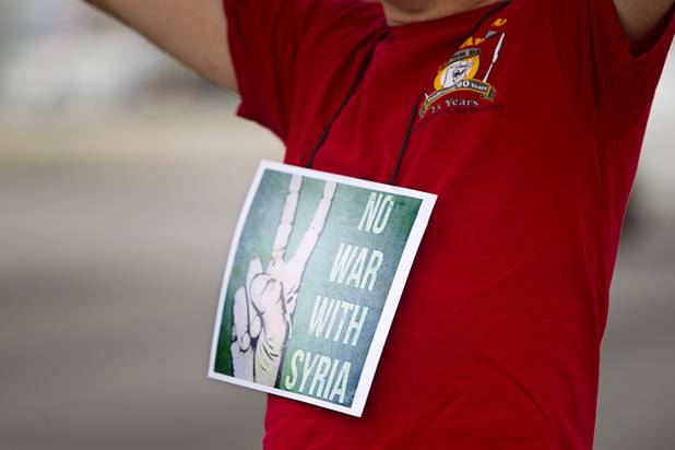 Stephen Davis wears a sign around his neck during a protest at the Tropicana Avenue overpass above I-15 Saturday, Sept. 7, 2013. About 50 people attended the protest.
