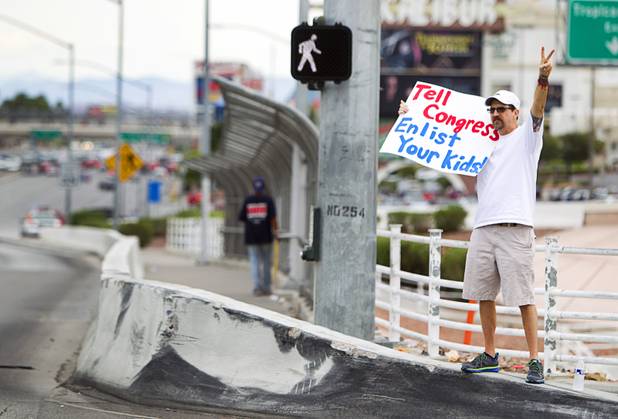 Kevin Driscoll expresses his opposition to proposed U.S. military action in Syria during a protest at the Tropicana Avenue overpass above I-15 Saturday, Sept. 7, 2013. About 50 people attended the protest.