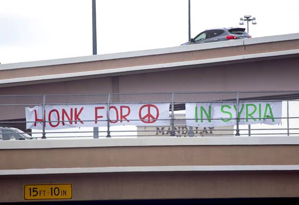 People express their opposition to proposed U.S. military action in Syria during a protest at the Tropicana Avenue overpass above I-15 Saturday, Sept. 7, 2013. About 50 people attended the protest.