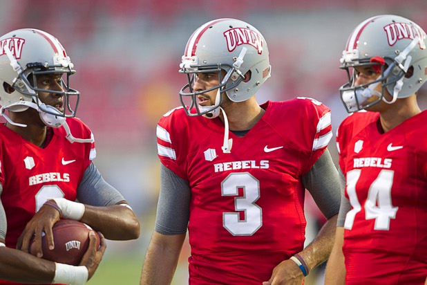 UNLV quarterbacks Caleb Herring, left, Nick Sherry, center, and Jared Lebowitz confer before UNLV's home opener against the University of Arizona at Sam Boyd Stadium Saturday, Sept. 7, 2013.