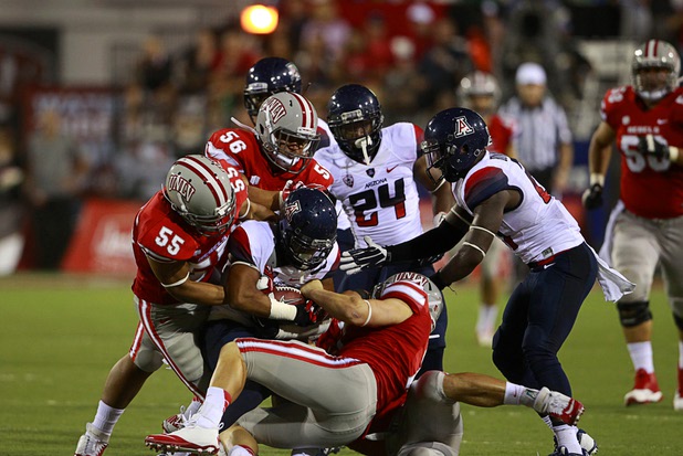 A host of UNLV defenders bring down University of Arizona wide receiver Johnny Jackson during UNLV's home opener against UA at Sam Boyd Stadium Saturday, Sept. 7, 2013. Clockwise from top left are: John Lotulelei (55), Malo Feula (56)and Marc Philippi (7). Trent Langham (50) is at bottom right.