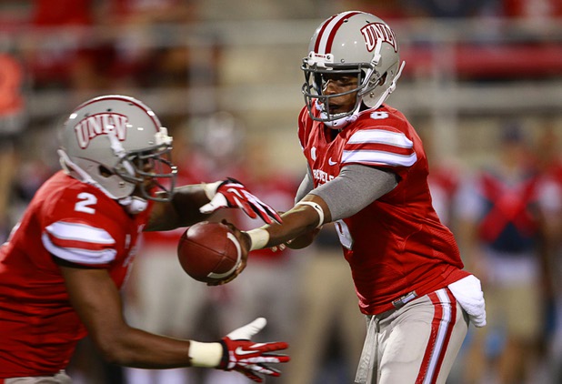 UNLV quarterback Caleb Herring hands the ball off to running back Adonis Smith during UNLV's home opener against the University of Arizona at Sam Boyd Stadium Saturday, Sept. 7, 2013.