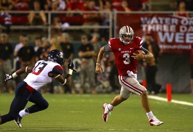 UNLV quarterback Nick Sherry, right, scrambles under pressure from University of Arizona's Devin Holiday during UNLV's home opener against UA at Sam Boyd Stadium Saturday, Sept. 7, 2013.