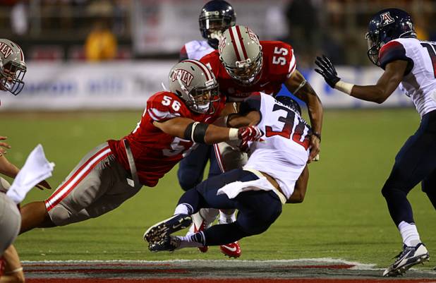 UNLV defenders Malo Feula,left, and John Lotulelei but the stop on University of Arizona's Johnny Jackson during UNLV's home opener against UA at Sam Boyd Stadium Saturday, Sept. 7, 2013.