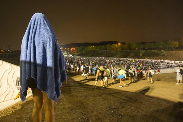 A athlete protects herself from the rain with a towel before the start of the Ironman 70.3 World Championship at Lake Las Vegas in Henderson Sunday, Sept. 8, 2013. More than 1,800 athletes from around the U.S. and 53 countries qualified for the event.
