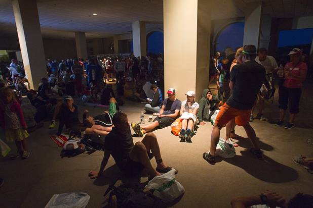 Athletes and spectators take cover from the rain as they wait for the start of the Ironman 70.3 World Championship at Lake Las Vegas in Henderson Sunday, Sept. 8, 2013. More than 1,800 athletes from around the U.S. and 53 countries qualified for the event.