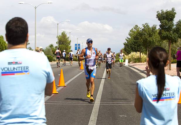 Volunteers cheer athletes as they run on Green Valley Parkway during the Ironman 70.3 World Championship in Henderson Sunday, Sept. 8, 2013. The 13.1 mile run comes after a 56-mile bicycle course and a 1.2-mile swim in Las Las Vegas. More than 1,800 athletes from around the U.S. and 53 countries qualified for the event.